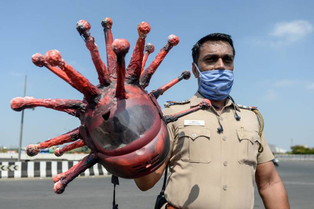 Indian police put on a unique helmet of the invisible SARS-CoV-2 virus to scare people out of their homes Picture 1