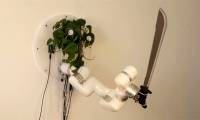 The machine system helps bonsai trees control a robot arm holding a knife